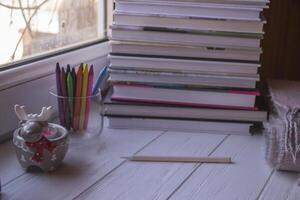 mysigt skrivbordet med böcker, ljus ljus och skön dekorationer. foto