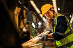 fabrik ingenjör kvinna stående självsäker till kontrollera panel växla. arbetstagare Arbetar på tung maskin på industri fabrik. arbetstagare kontroll timmer av rå trä material. smart industri arbetstagare fungerar. foto