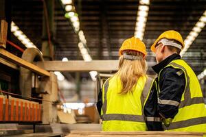 tillbaka av fabrik ingenjör arbetare stående till kontrollera panel växla. människor Arbetar på tung maskin på industri fabrik. med maskineri Utrustning växt teknologi. smart industri arbetstagare fungerar. foto