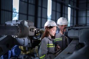 ingenjörer kolla upp kontrollera tung maskin robot ärm. olika team av industriell robotik ingenjörer samlade in runt om maskin. professionell maskineri operatörer reparera elektrisk robot på ljus digital panel. foto