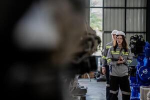 ingenjörer kolla upp kontrollera tung maskin robot ärm. olika team av industriell robotik ingenjörer samlade in runt om maskin. professionell maskineri operatörer reparera elektrisk robot på ljus digital panel. foto