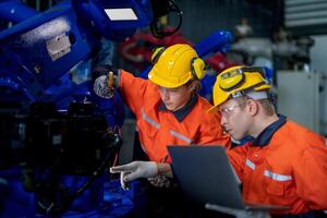 manlig ingenjör arbetare underhåll automatisk robot ärm maskin i en fabrik. arbetstagare kontroll och reparation automatisk robot hand maskin. tekniker arbetstagare kolla upp för reparera fabrik maskin. foto