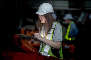 företag ingenjörer möte och kontroll ny maskin robot. arbetare gående på lager industri svetsning maskin. företag förhandling begrepp och teknologi. kvinnor använder sig av smart läsplatta till närvarande man. foto