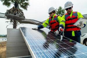 ingenjör män inspektera moduler av solceller cell paneler. industriell förnybar energi av grön kraft. arbetare förbereda material innan konstruktion på webbplats med de stack av paneler på bakgrund. foto