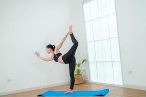 två kvinnor självsäker Träning yoga. atletisk kvinnor i sportkläder håller på med kondition stretching övningar på Hem i de levande rum. sport och rekreation begrepp. yoga lärare är portion ung kvinna. foto