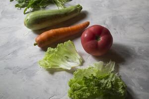 grupp av grönsaker på en kök tabell. Ingredienser för matlagning sallad. foto