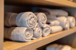 ai genererad stänga upp av hylla med rullad bad handdukar på hotell spa. foto