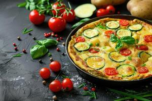 ai genererad omelett med tomater zucchini och potatisar på mörk bakgrund friska diet mat för frukost gott morgon- mat. foto
