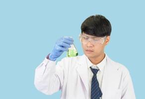 asiatisk man studerande forskare eller läkare i reagens blandning laboratorium i en vetenskap forskning laboratorium med testa rör av olika storlekar. på de golv i laboratorium kemi labb blå bakgrund. foto