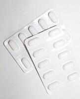 apotek apotek koncept. förpackningar av vita piller packade i blister med kopia utrymme isolerad på en vit bakgrund. fokus på förgrunden, mjuk bokeh. foto