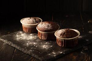 choklad muffins med pulveriserad socker på en svart bakgrund. fortfarande liv stänga upp. mörk lynnig. mat Foto. foto