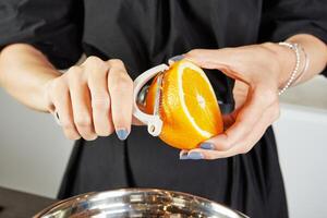hand klämma orange halv över en skål på vit bakgrund. ljus och vibrerande färger göra den idealisk för recept, friska äter, och uppfriskande sommar drycker. färsk och saftig begrepp. foto