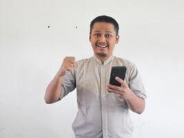 asiatisk man innehav hans mobil telefon med allvarlig uttryck foto