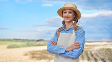 kvinna jordbrukare sugrör hatt förkläde stående jordbruksmark leende kvinna agronom specialist jordbruk jordbruksnäringen Lycklig positiv caucasian arbetstagare jordbruks fält foto