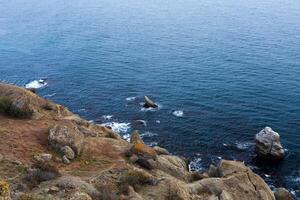 hav klippa i främre av skön blå vatten foto
