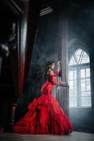 kvinna årgång röd klänning gammal slott skön prinsessa i förförisk klänning foto