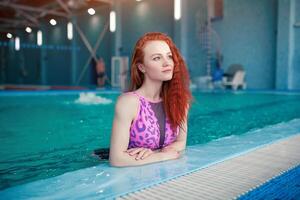 skön ung kvinna i de inomhus- simning slå samman. atletisk sexig flicka. friska livsstil foto