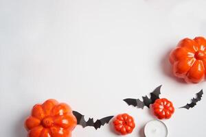 halloween bakgrund, orange dekorativ plast pumpa svart papper fladdermus vit kartong tacksägelse hälsning kort foto