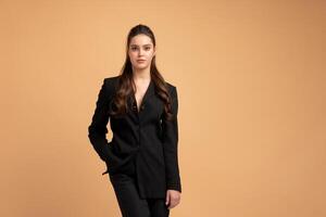 ung företag kvinna ett hand i ficka klädd svart jacka stående studio isolerat på Färg bakgrund. foto