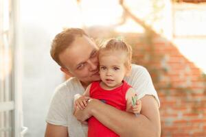 en ung pappa kyssar hans liten dotter på de kind foto