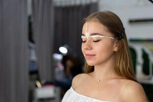 ung kosmetolog caucasian flicka innehar modell ögonbryn korrektion foto