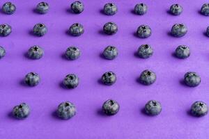 färgrik frukt mönster av blåbär på lila bakgrund. topp se. foto
