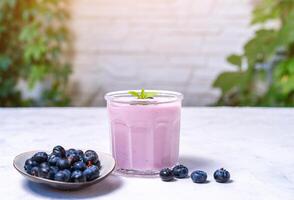 gott färsk blåbär yoghurt skaka efterrätt i glas stående på vit tabell bakgrund. foto