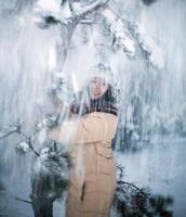 skön flicka har roligt i de vinter- snöig skog foto