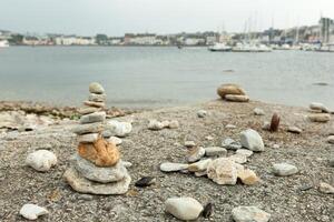 stenar pyramid på sten strand symboliserar stabilitet, zen, harmoni, balans. grund djup av fält. foto