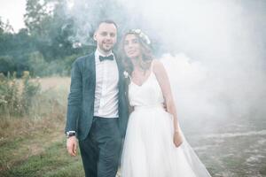 skön brud och brudgum. bröllop ceremoni i natur. rök bomber. foto