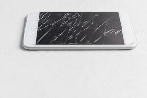 modern mobil smartphone med bruten skärm på vit bakgrund foto