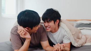 stilig asiatisk gay par pratar på sängen hemma. ung asiatisk lgbtq kille glad slappna av vila tillsammans spendera romantisk tid efter att ha vaknat i sovrummet på modernt hus på morgonen koncept. foto