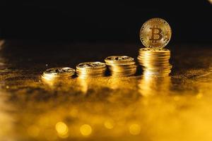 Bitcoin tillväxt, bitcoin-mynt staplade på svart guldbakgrund foto