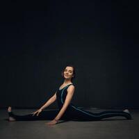 kvinna praktiserande yoga mot en mörk texturerade vägg foto