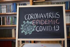 utbrott varning. skriven vit krita på svarta tavlan i förbindelse med epidemi av coronavirus över hela världen. foto