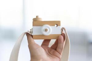 leksak trä- kamera för barn eller dekoration unge innehav i hand foto