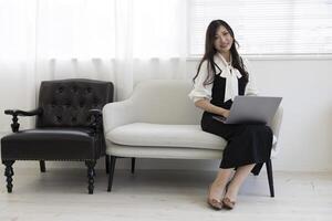 en japansk kvinna kontroll smartphone förbi avlägsen arbete i de Hem kontor foto