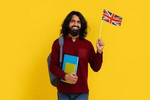 leende indisk kille studerande som visar flagga av bra storbritannien foto