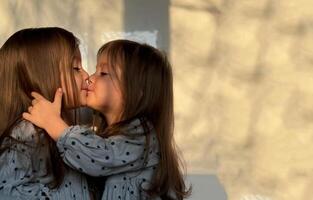 porträtt av blandad lopp tvilling bebis flickor kissing och kramas varje Övrig. Lycklig syskon dag. foto