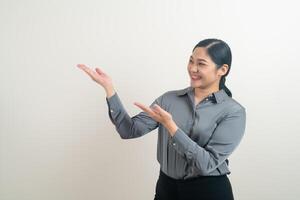 asiatisk kvinna med handen presenterar på bakgrunden foto