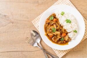 japanskt curryris med skivat fläsk, morot och lök foto