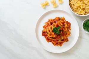 farfalle pasta i tomatsås med persilja foto