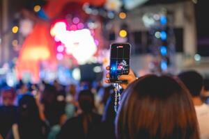 människor innehav smart telefon och inspelning och fotografering i konsert , silhuett av händer med mobil , händelse bakgrund begrepp foto