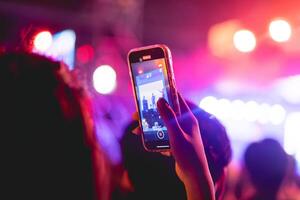 människor innehav smart telefon och inspelning och fotografering i konsert , silhuett av händer med mobil , händelse bakgrund begrepp foto