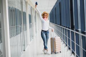redo för de resa. kvinna håll pass i hand med bagage på flygplats bakgrund. hög säsong och semester begrepp. koppla av och livsstilar foto