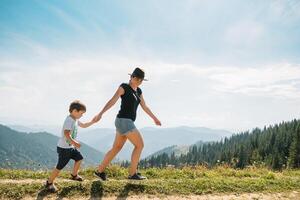 ung mamma med bebis pojke reser. mor på vandring äventyr med barn, familj resa i berg. nationell parkera. vandra med barn. aktiva sommar högtider. foto