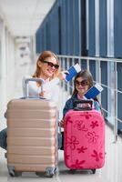 mor och liten dotter med bagage på flygplats terminal redo för semester. foto