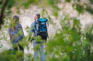 en par av turister i tid av resa stål och beundra de skön berg landskap. de kille kramar de flicka. de begrepp av kärlek, ömhet och rekreation foto