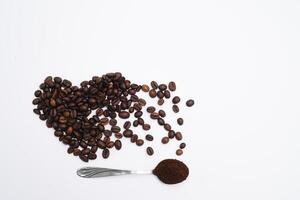 hjärta formad kaffe bönor med grunder och sked foto
