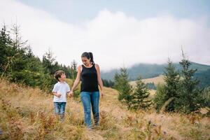 ung mamma med bebis pojke reser. mor på vandring äventyr med barn, familj resa i berg. nationell parkera. vandra med barn. aktiva sommar högtider. foto